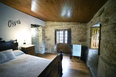 a bedroom with a bed and a wooden ceiling at As Casas Ribeira Sacra in Chantada