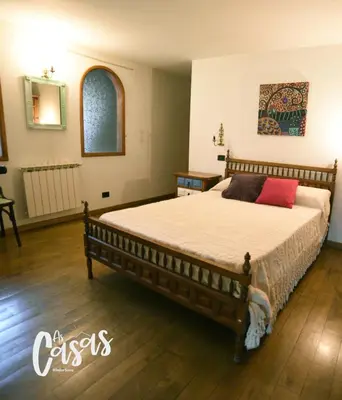 a bedroom with a large bed with red pillows on it at As Casas Ribeira Sacra in Chantada