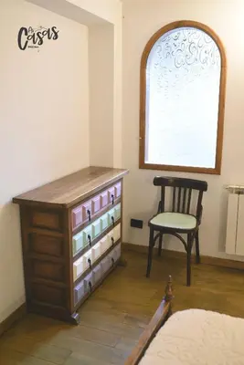 a dresser and a chair in a room with a window at As Casas Ribeira Sacra in Chantada