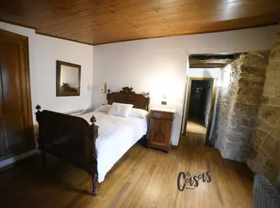 a bedroom with a bed and a stone wall at As Casas Ribeira Sacra in Chantada