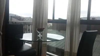 a table with a wine glass on a balcony at Descanso Termal in Ourense