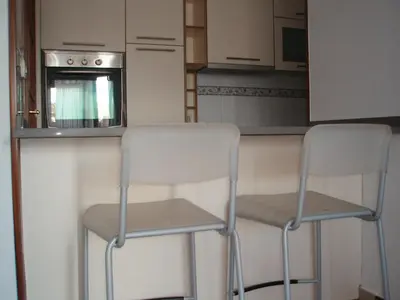 two white chairs in a kitchen with an oven at Descanso Termal in Ourense