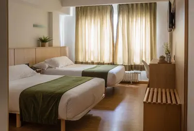 a hotel room with two beds and a window at Hotel Crisol de las Rías in Miño