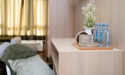 a table with bottles and a vase with flowers on it at Hotel Crisol de las Rías in Miño