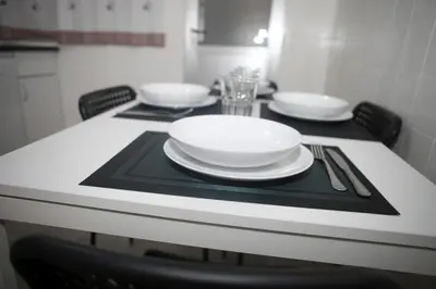 a table with plates and utensils on top of it at El Apartamento de María in Lugo