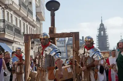 a group of men dressed in historical costumes walking down a street at El Apartamento de María in Lugo