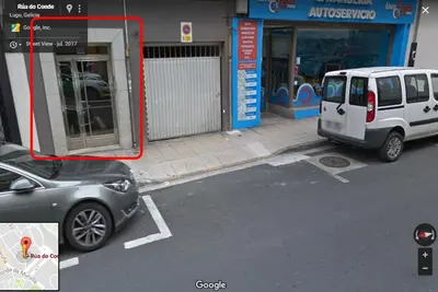 a white car parked in a parking lot next to a street at El Apartamento de María in Lugo