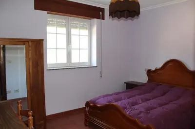 a bedroom with a purple bed and a window at Casa do Xastre in Baralla
