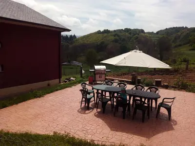 a patio with a table and chairs and an umbrella at Casa do Xastre in Baralla