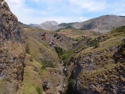 a mountain valley with a river in the middle at Albergue Casa del Pescador in Ambasmestas