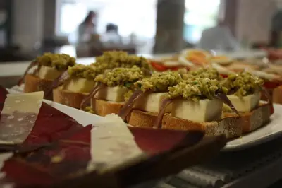 a plate of food with cheese and greens on it at Hotel Pontes do Eume in Puentes de García Rodríguez