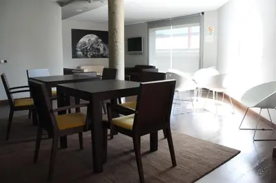 a dining room with a black table and chairs at Hotel Pontes do Eume in Puentes de García Rodríguez