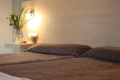 a bedroom with two beds and a vase with flowers at Hotel Pontes do Eume in Puentes de García Rodríguez