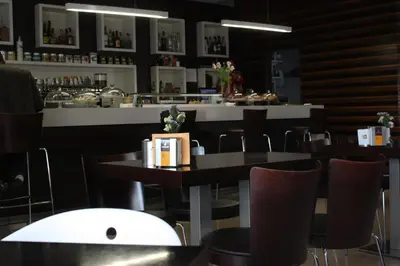 a restaurant with tables and chairs and a bar at Hotel Pontes do Eume in Puentes de García Rodríguez