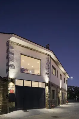 a building with a large window and a garage at Casa la Devesa de Sanabria in Remesal