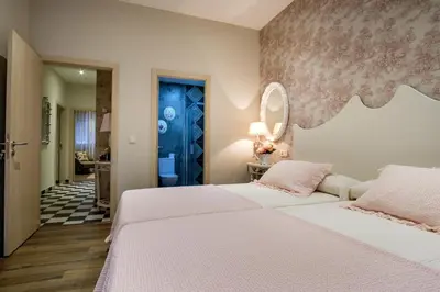 a bedroom with two white beds and a blue door at La Casona de Nené in Arzúa