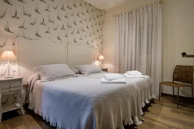 a bedroom with a bed with a white bedspread at La Casona de Nené in Arzúa
