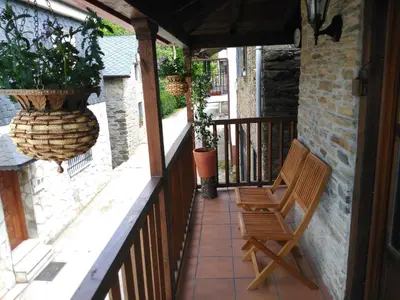 a balcony with a chair and potted plants on it at Casa Bell in Manzanedo de Valdueza
