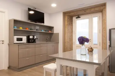 a kitchen with a table with a vase of flowers at Albergue Linares in Santiago de Compostela