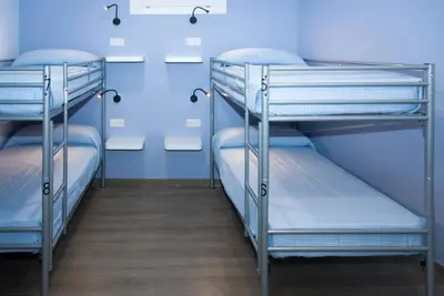 two bunk beds in a room with blue walls at Albergue Linares in Santiago de Compostela