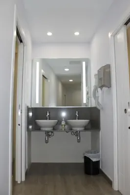 a bathroom with two sinks and a large mirror at Albergue Linares in Santiago de Compostela