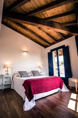 a bedroom with a large bed with a red blanket at Apartamentos Ribeira Sacra in Parada del Sil