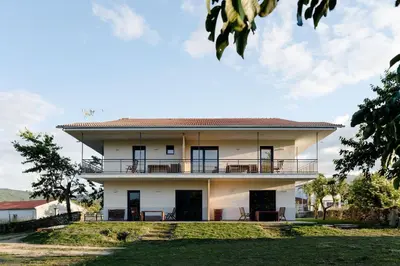 a large white house with a balcony at Apartamentos Ribeira Sacra in Parada del Sil