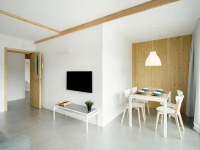 a dining room with a table and a tv on a wall at Apartamentos Ribeira Sacra in Parada del Sil