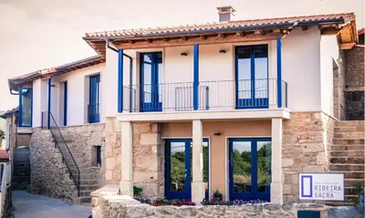 a house with blue doors and windows at Apartamentos Ribeira Sacra in Parada del Sil
