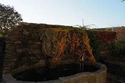 a stone fountain with a statue of a woman at A Fonte das Hortas Residencial in Santiago de Compostela