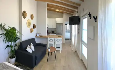 a living room with a blue couch and a kitchen at A Fonte das Hortas Residencial in Santiago de Compostela