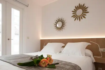 a bedroom with a bed with flowers and a mirror at A Fonte das Hortas Residencial in Santiago de Compostela