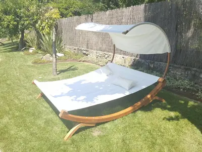 a chair sitting in the grass in a yard at A Fonte das Hortas Residencial in Santiago de Compostela