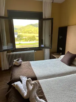 a bedroom with two beds and a large window at Casa Blanco Conde in Laza