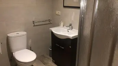 a bathroom with a white toilet and a sink at Casa Blanco Conde in Laza