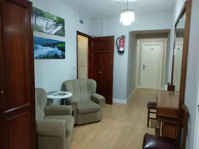 a living room with two chairs and a table at Hostal Buenavista in San Ciprián