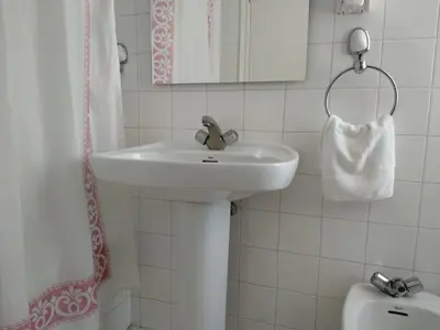 a bathroom with a sink and a mirror and a toilet at Hostal Buenavista in San Ciprián
