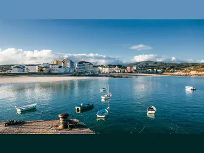 a group of boats in the water near a beach at Hostal Buenavista in San Ciprián