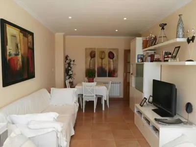 a living room with a white couch and a television at Foz Playa y Mar by I Love Norte in Foz