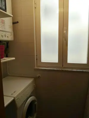 a bathroom with a window and a washing machine at Foz Playa y Mar by I Love Norte in Foz