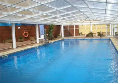 a large blue swimming pool with a ceiling at Foz Playa y Mar by I Love Norte in Foz
