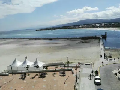 a beach with white tents and a beach with water at Foz Playa y Mar by I Love Norte in Foz