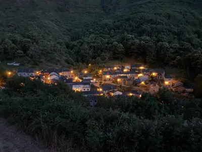 a town lit up at night on a hill at Casa de Abril 1 in San Cristóbal de Valdueza