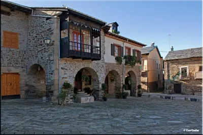 a stone building with a balcony on a street at Casa de Abril 1 in San Cristóbal de Valdueza