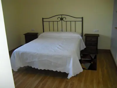 a bedroom with a white bed with two night stands at La Candela in Rabanal del Camino