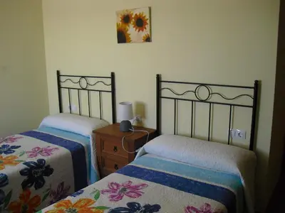 a bedroom with two beds and a dresser and a picture at La Candela in Rabanal del Camino