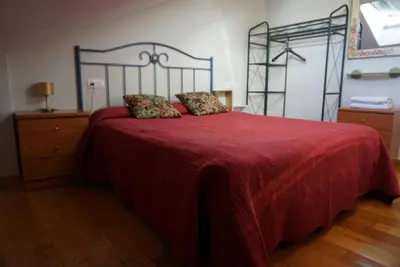a bedroom with a bed with a red blanket at Casa Morrosco in Molinaseca