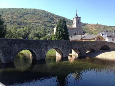 a stone bridge over a river in a town at Casa Morrosco in Molinaseca