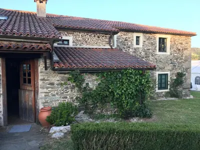 a stone house with a red tile roof at Casa Grande do Soxal in Cesuras