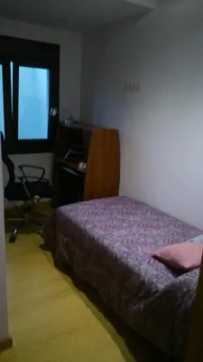 a bedroom with a bed and a desk and a chair at Apartamento con balcón in Viveiro